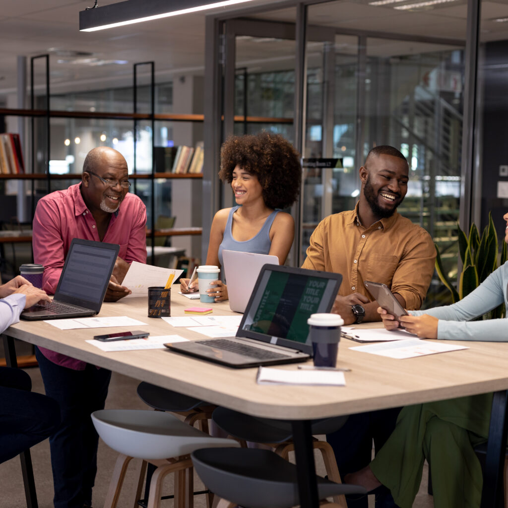 smiling colleagues sat in a meeting room discussing the Neurodiversity Report