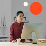 Image of a young creative employee in the workplace with one large orange circle and smaller beige circle.